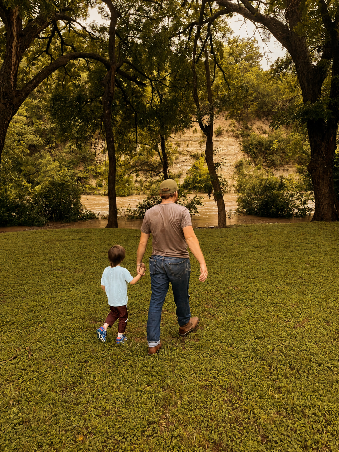 Parent and child walking together beside a river