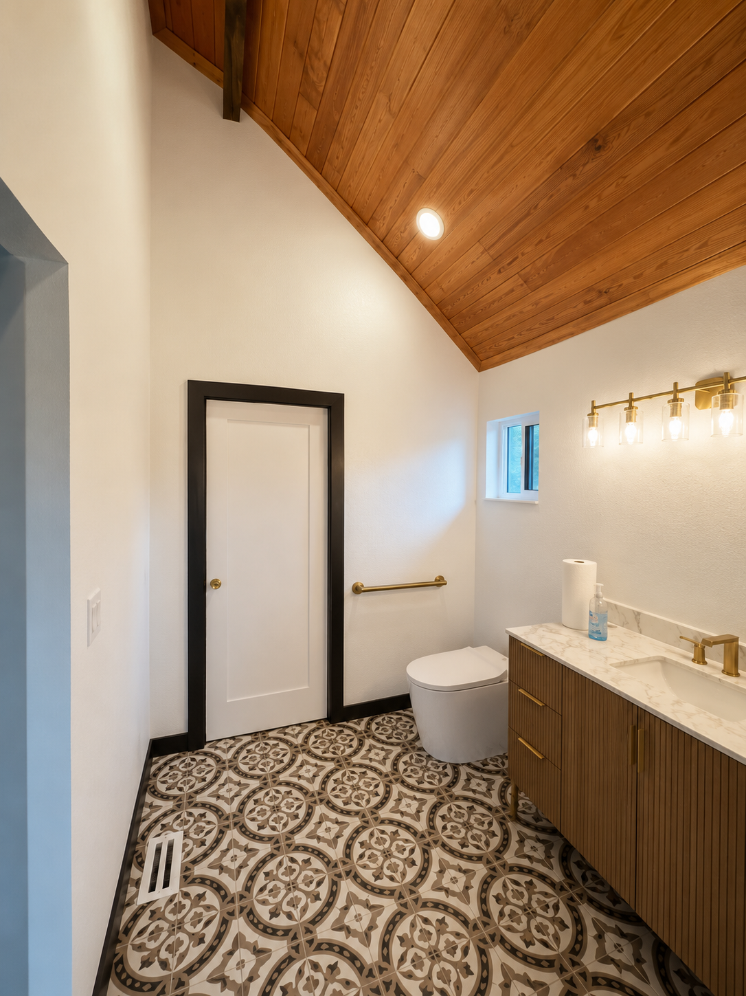 Completed bathroom with warm wood ceiling detail