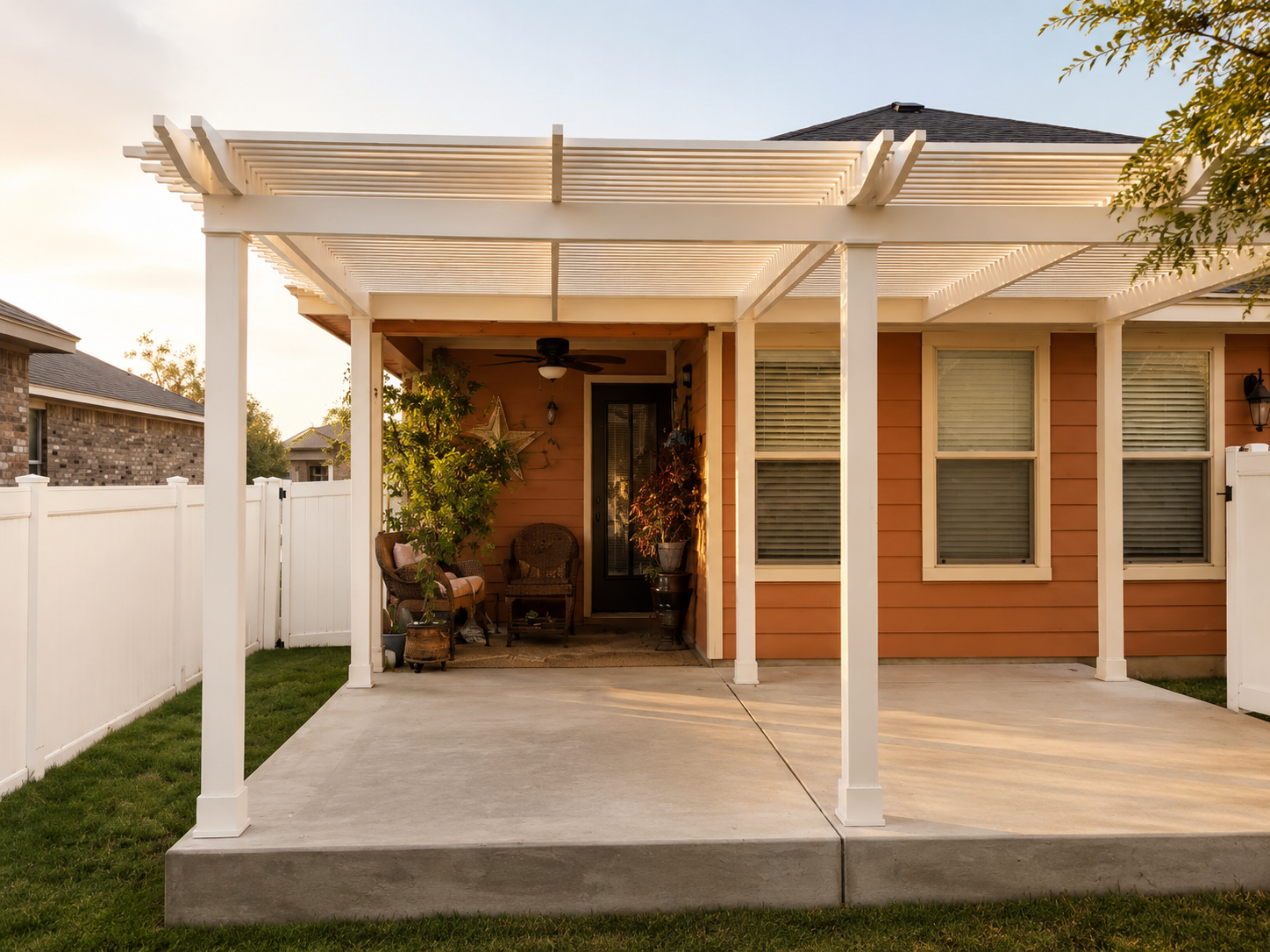 Completed covered outdoor living space with a white pergola and warm afternoon light